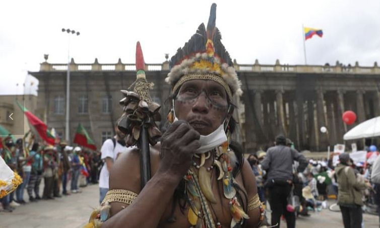 An Indigenous man arrives to Plaza Bolivar to take part in a demonstration against the government’s handling of a wide range of issues including the economic fallout of the pandemic and implementation of the peace accord, in Bogota, Colombia, Wednesday, Oct. 21, 2020. Indigenous leaders, students and union members gathered at in the historic square waving flags and banners decrying the government nearly one year after massive protests rocked the country only to fizzle with little to show by way of reform. (AP Photo/Fernando Vergara)